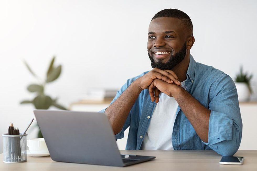 Happy Man on Laptop που εργάζεται από το σπίτι με ένα ευέλικτο πρόγραμμα εργασίας