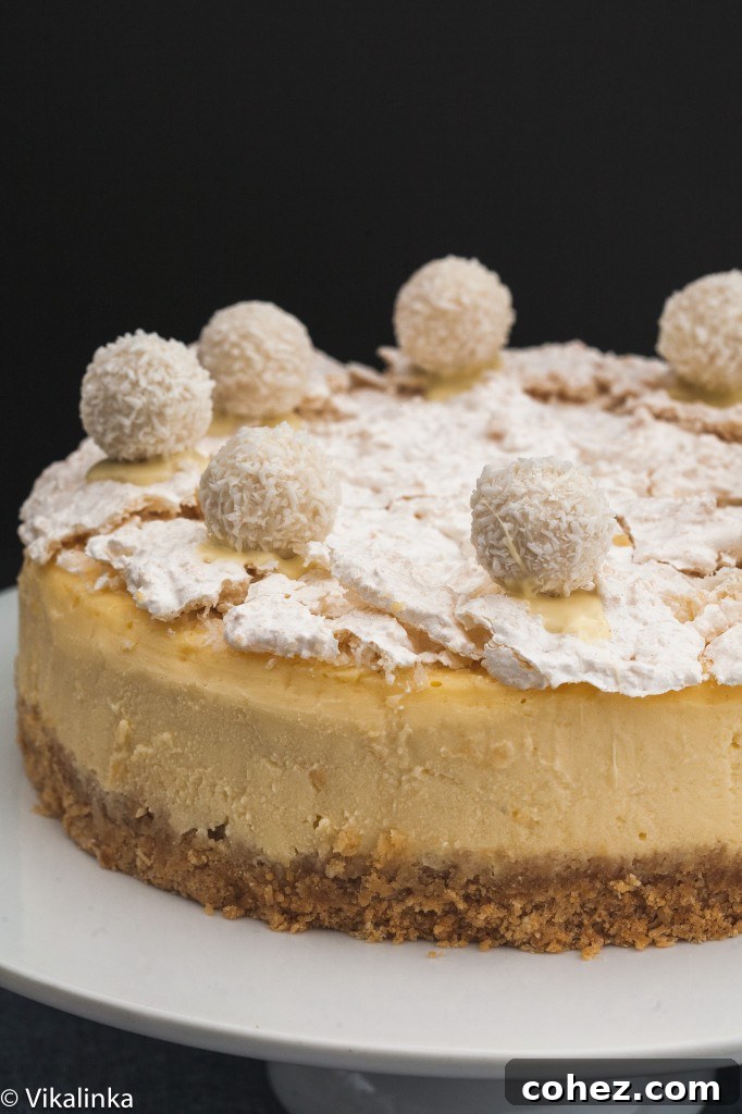 An angled close-up view of the Raffaello Cheesecake, showing the texture of the meringue topping and the smooth, creamy filling.