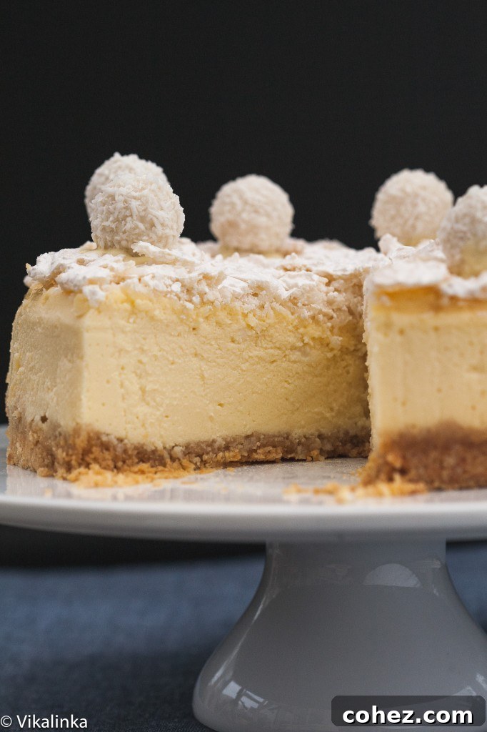 A Raffaello Cheesecake with a slice removed, showing the clean cut and the rich, creamy interior.