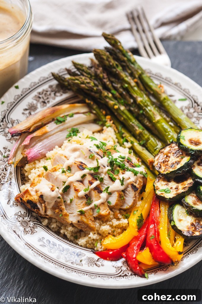 Mediterranean couscous bowl in small dish showing spread of ingredients including Moroccan chicken