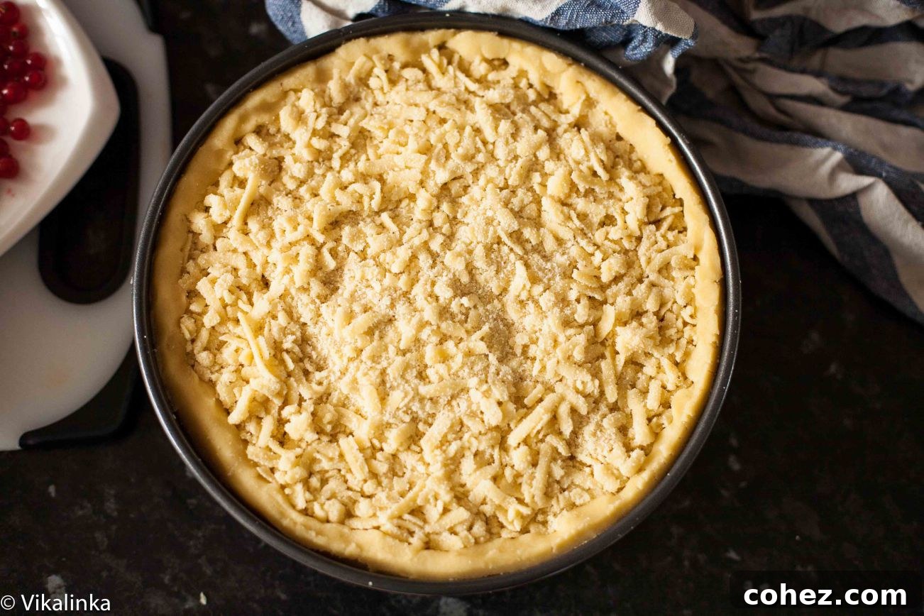 Apricot Crumble Cheesecake 7 Top-down view of the apricot cheesecake in a springform pan, covered with the grated crumb topping before going into the oven.