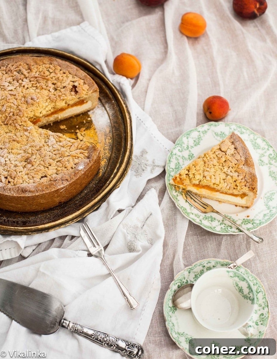 Apricot Crumble Cheesecake 8 A slice of Crumb Apricot Cheesecake beautifully plated next to the remaining whole cake, showing off its delicate layers and inviting texture.