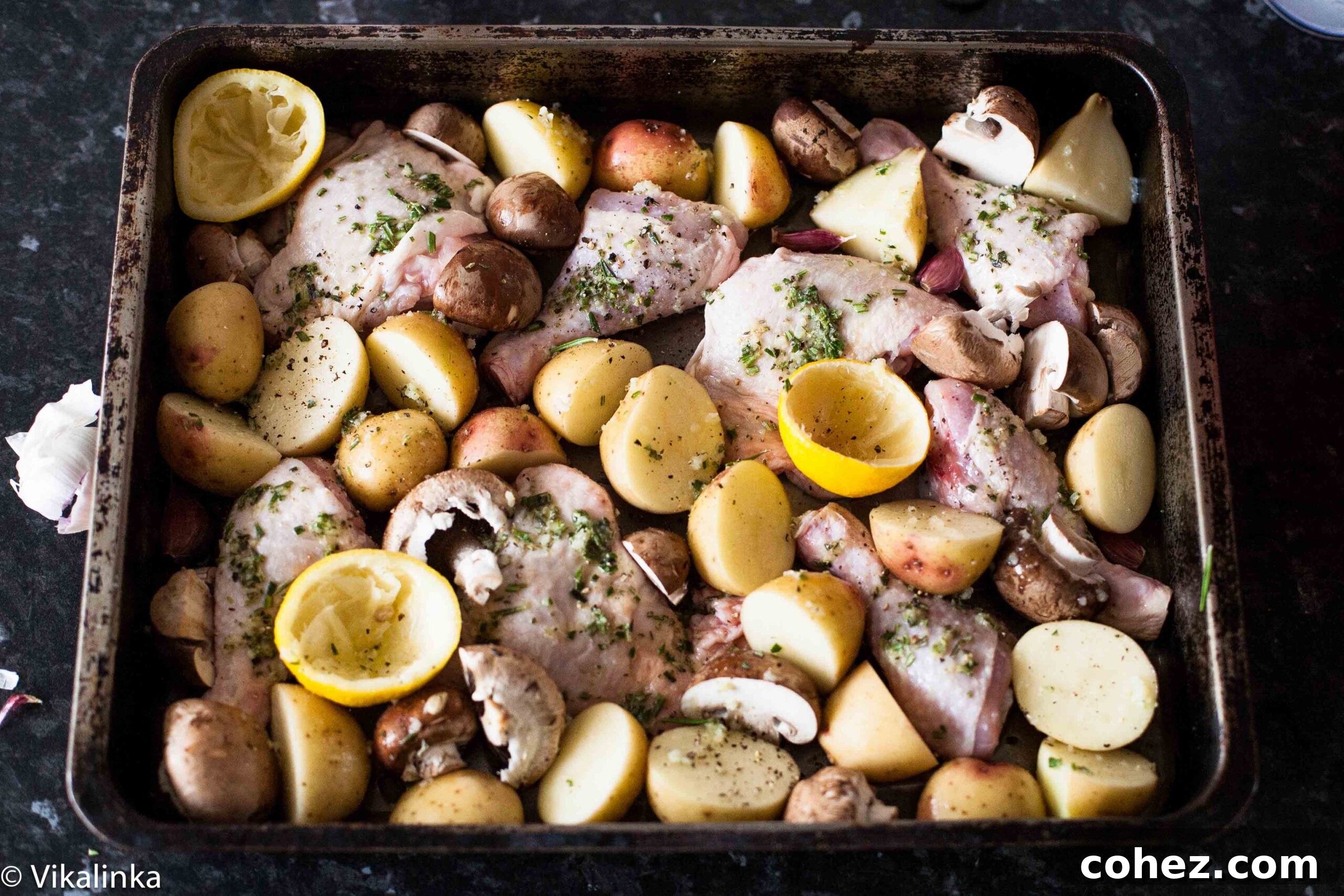 Close-up of perfectly roasted rosemary lemon chicken and potatoes on a pan