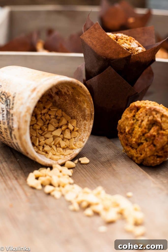 A rustic canister overflowing with chunks of golden toffee, with a soft focus on freshly baked muffins in the background, symbolizing the sweet additions to the recipe