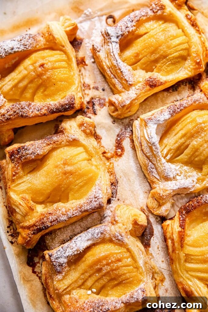 Puff pastry pear tarts on a rustic board, elegantly arranged for serving.
