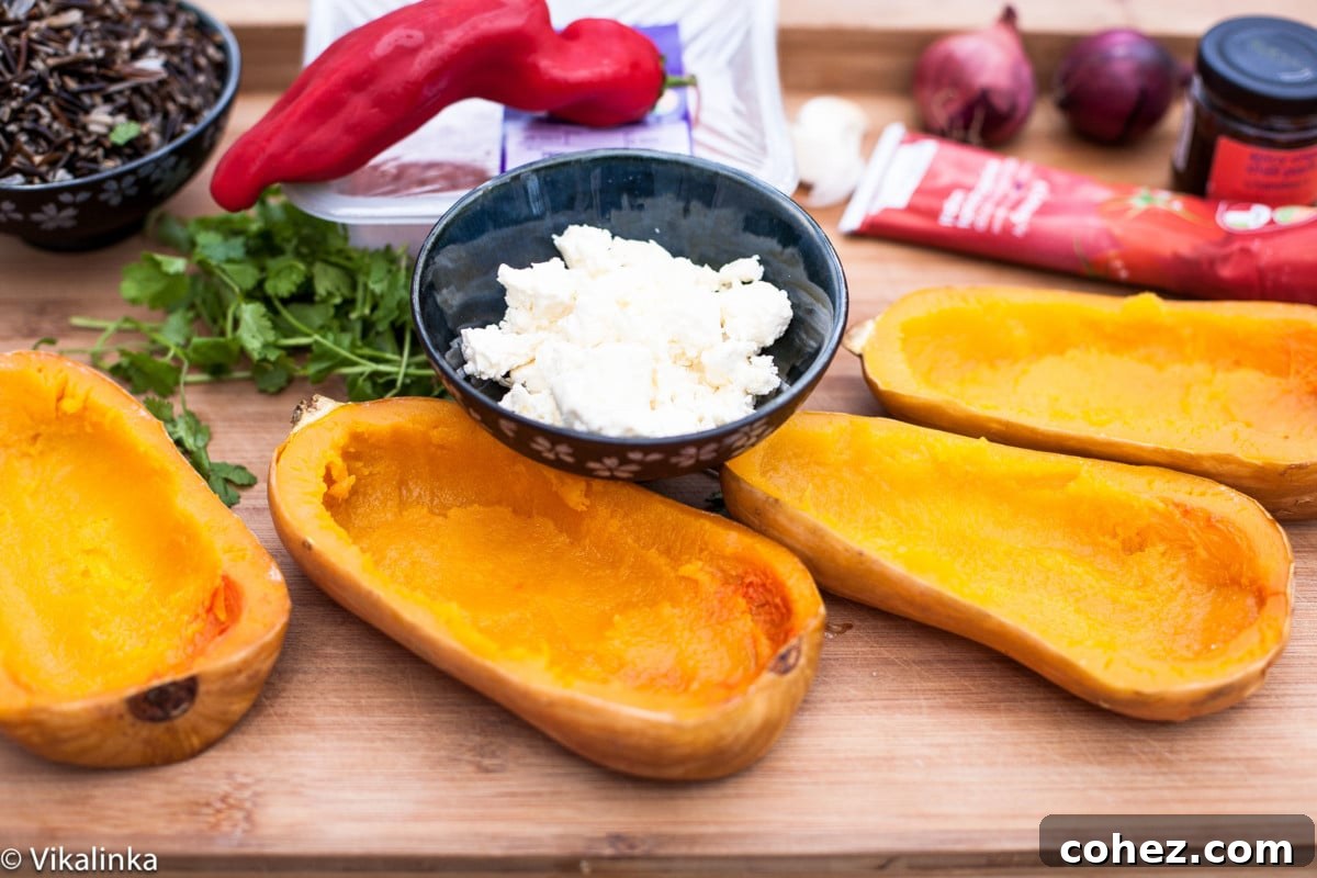 A collection of fresh ingredients laid out for making stuffed squash, including squash, vegetables, and ground turkey.