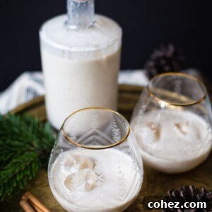 Two glasses of eggnog next to a bottle, ready to be served for holiday festivities.