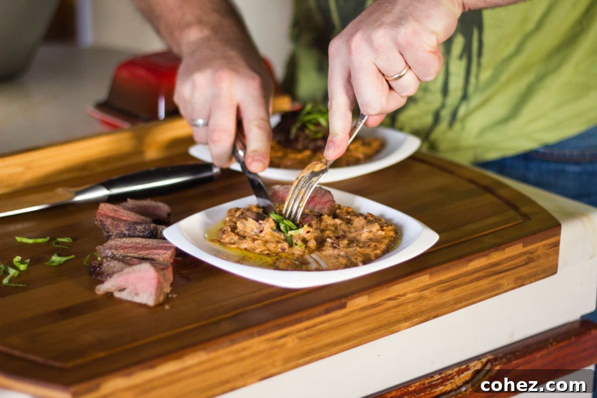 Slicing a Venison Steak Diane on a wooden cutting board to reveal its tender interior