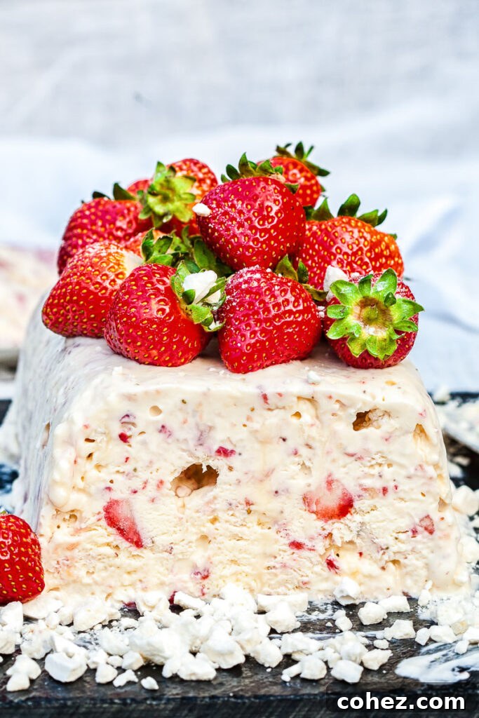 Side view of eton mess semifreddo, garnished with fresh strawberries