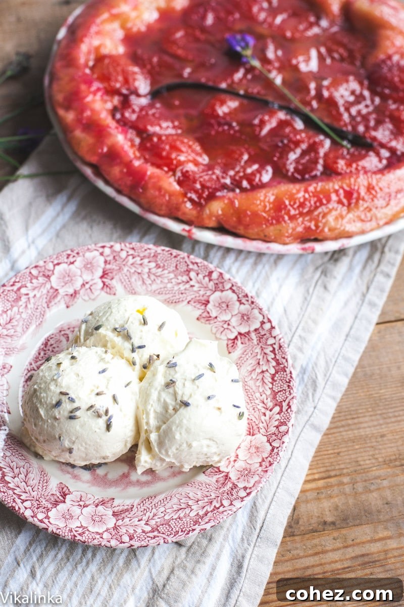 three scoops of whipped cream sprinkled with lavender, with a plum tarte tatin in the blurred background