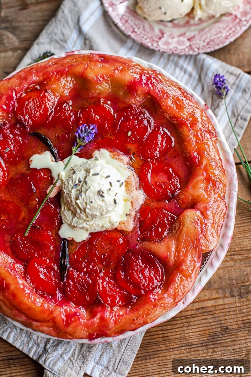 Plum tarte tatin topped with lavender whipped cream, garnished with fresh lavender