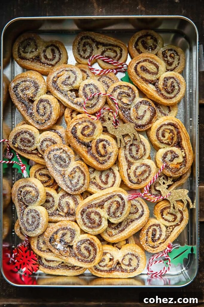 A charming storage container filled with golden palmiers and surrounded by subtle Christmas decorations.