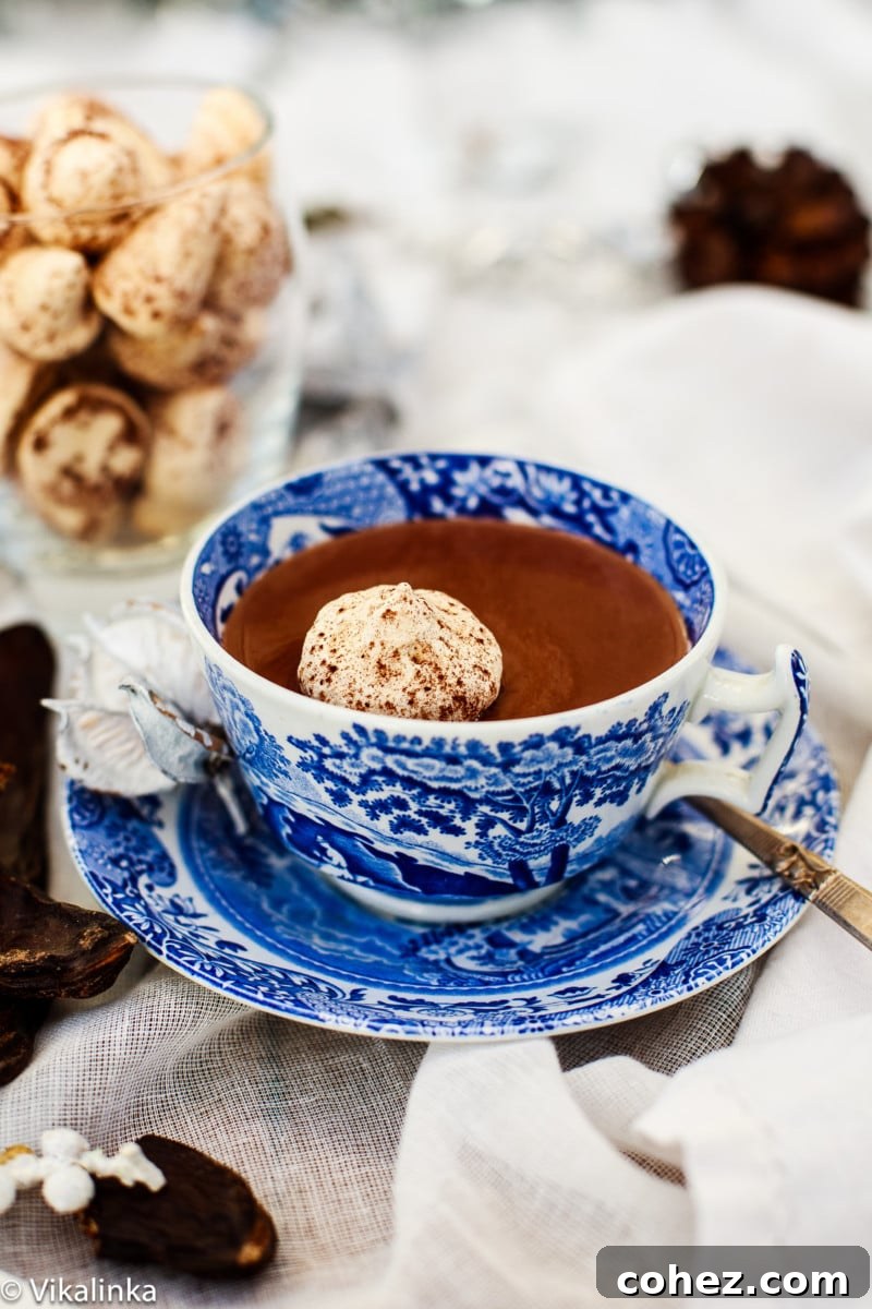 Close-up of creamy Italian Hot Chocolate topped with a perfectly floating meringue kiss, ready to be enjoyed.