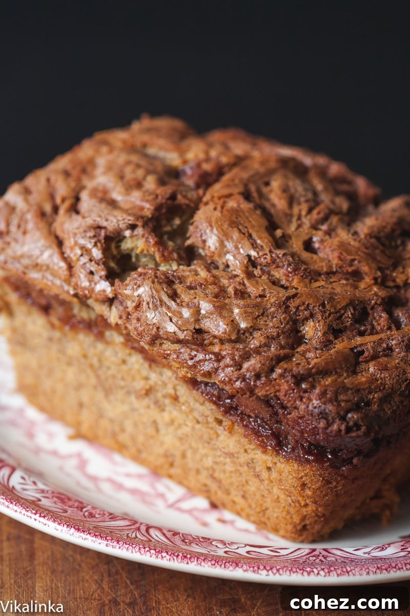 An overhead view of a freshly baked Nutella Banana Loaf, showcasing the beautiful Nutella swirls on the surface.