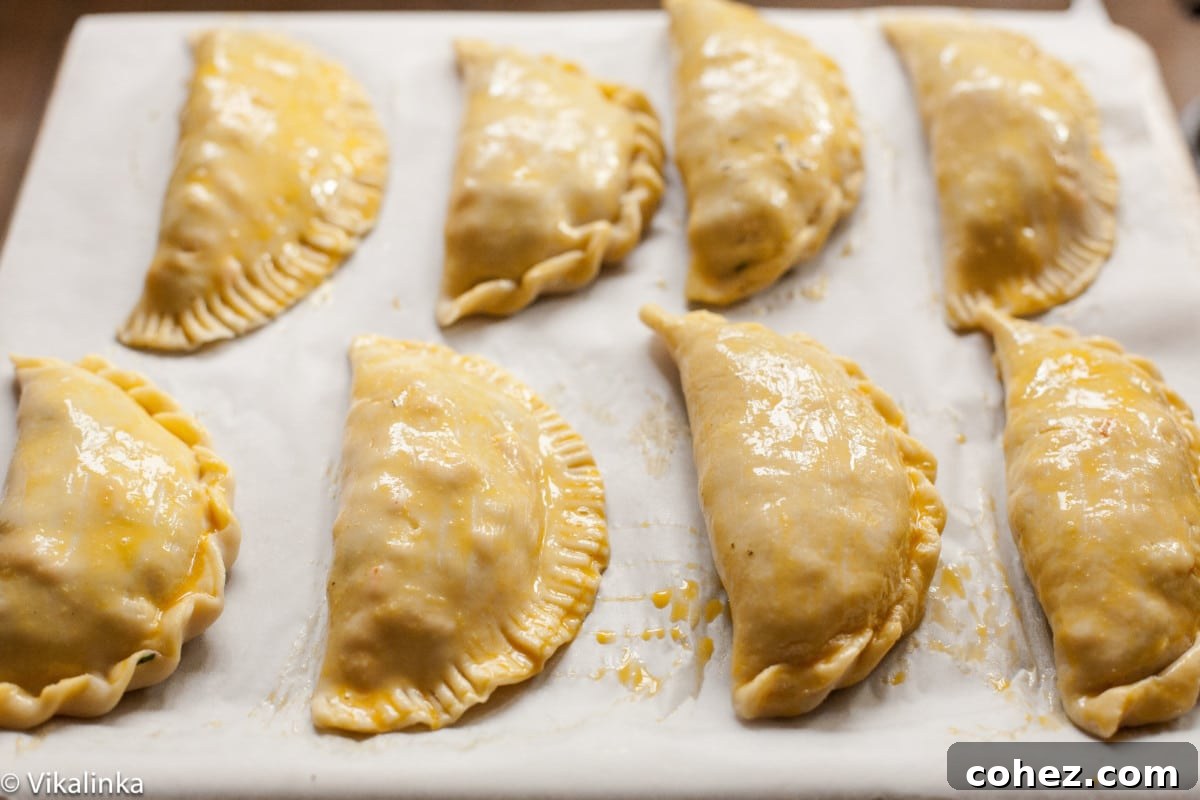 Cornish Comfort Steak and Sweet Potato Pasty 5 Unbaked Cornish pasties lined up on a baking sheet, ready for the oven