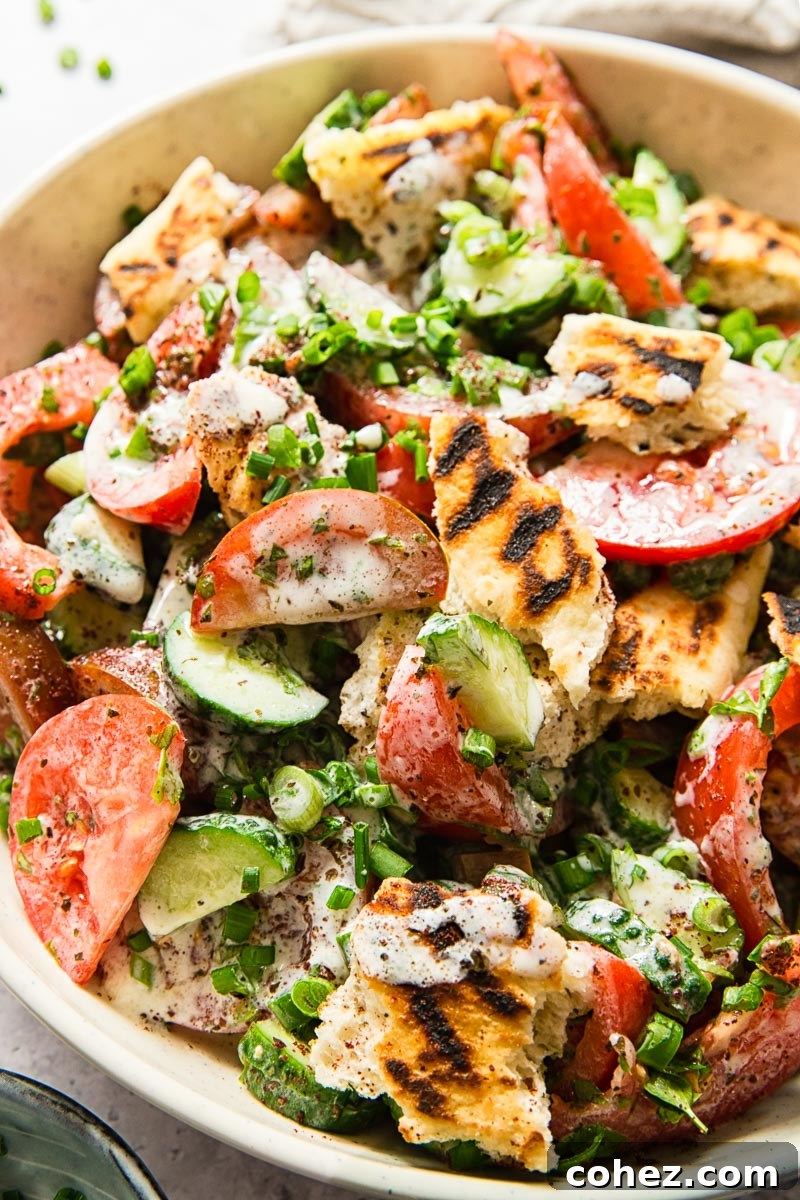 Crisp & Tangy Middle Eastern Fattoush 5 Close-up of Lebanese Fattoush salad with vibrant tomatoes and cucumbers, drizzled with a tangy buttermilk dressing.