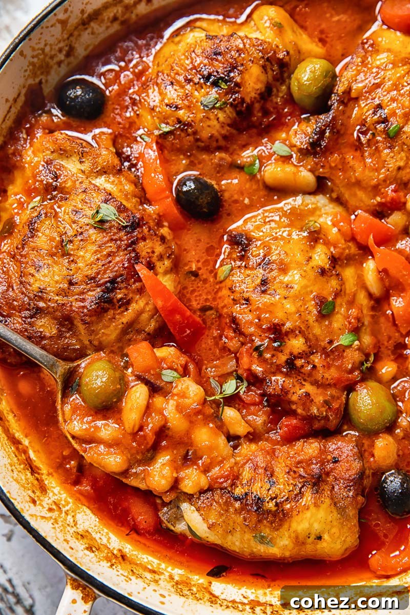 Spanish chicken in a pan close up, showing the rich tomato sauce and ingredients