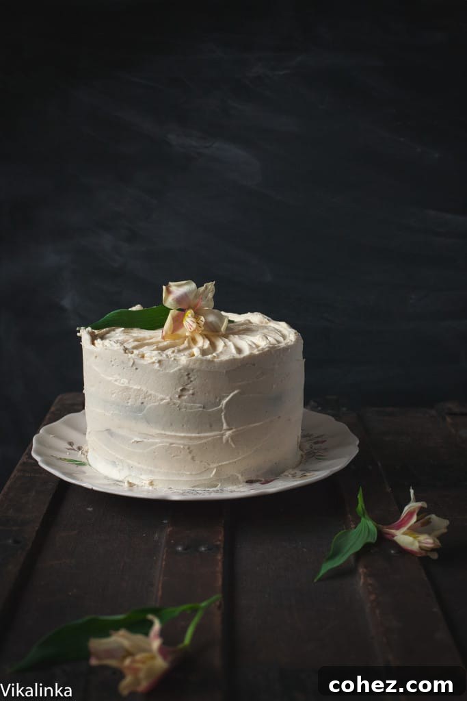 Side view of the pumpkin and chocolate cake against a dark background, showcasing its tall, elegant layers and smooth frosting