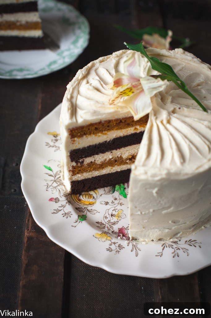 An elegant angled view of the pumpkin and chocolate cake with a single slice carefully removed, highlighting its beautiful layers and the smooth, creamy frosting
