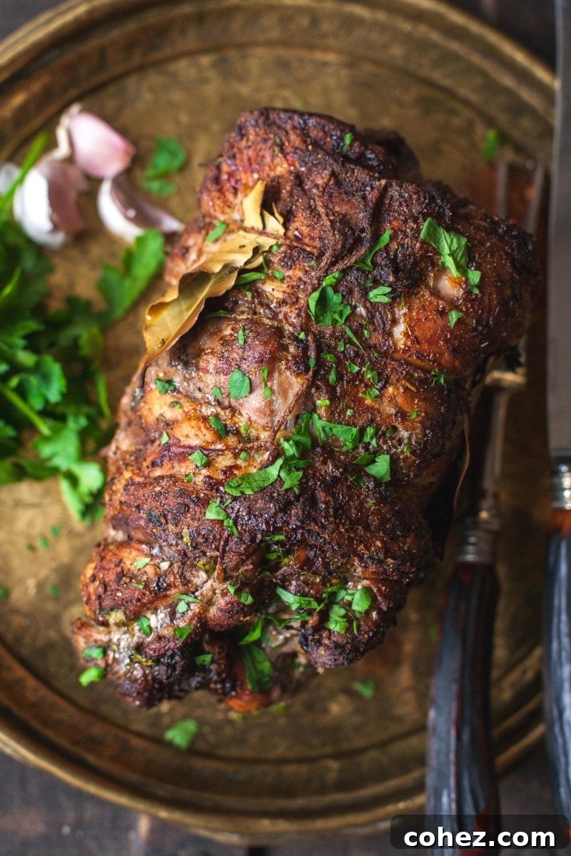 Top-down view of a perfectly cooked pork shoulder roast, golden-brown and glistening.