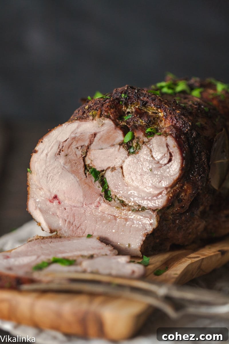 Side view of a beautifully sliced pork shoulder roast, revealing its tender, juicy interior.