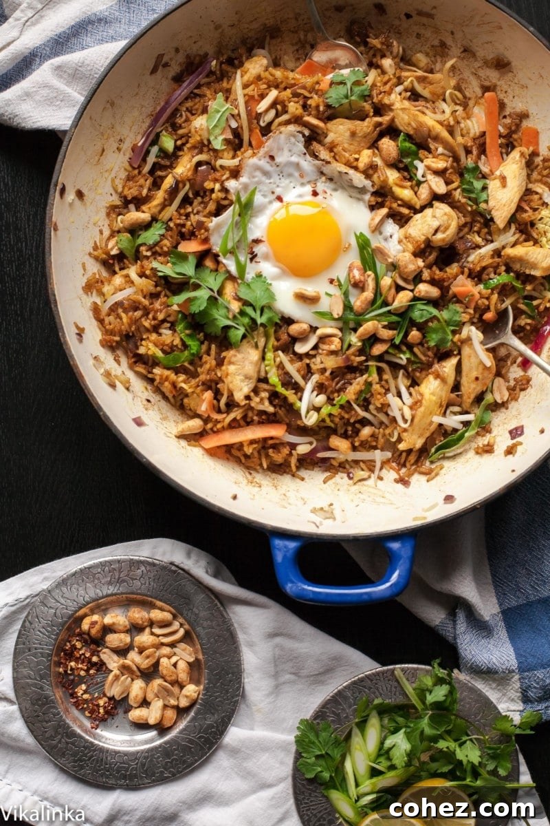 20-Minute Nasi Goreng Authentic Indonesian Fried Rice 4 Nasi Goreng in a pan next to a dish of peanuts, ready to be served