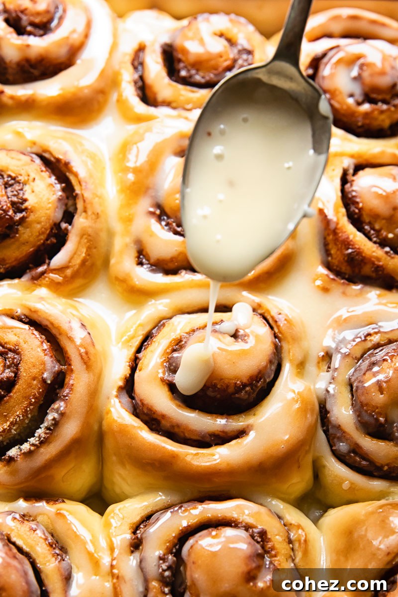 Glazing Chocolate Nutella Rolls Warm chocolate rolls being generously drizzled with vanilla sugar icing, creating a beautiful glaze.