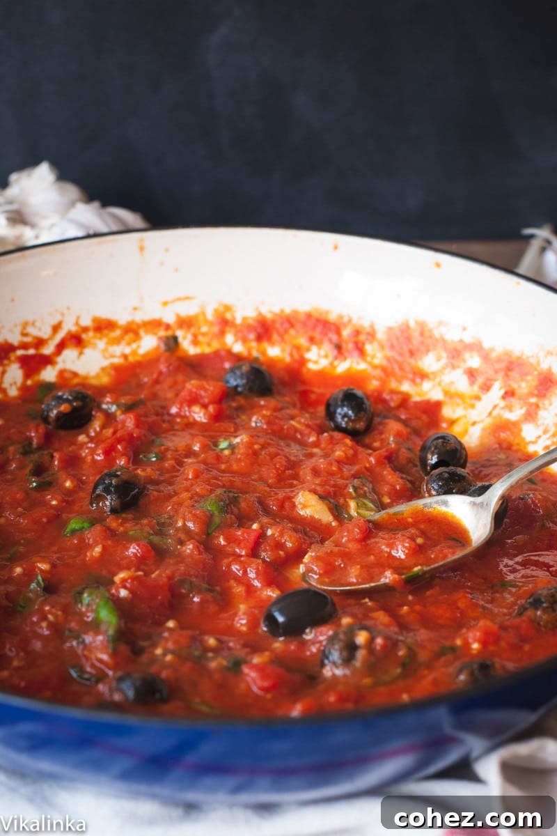 tomato sauce with black olives in a blue pan