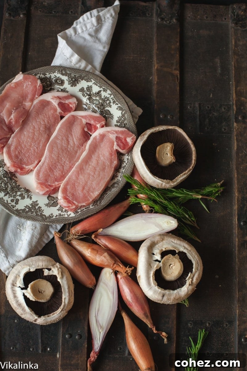 to down view of raw pork loin steaks, field mushroom, shallots and rosemary
