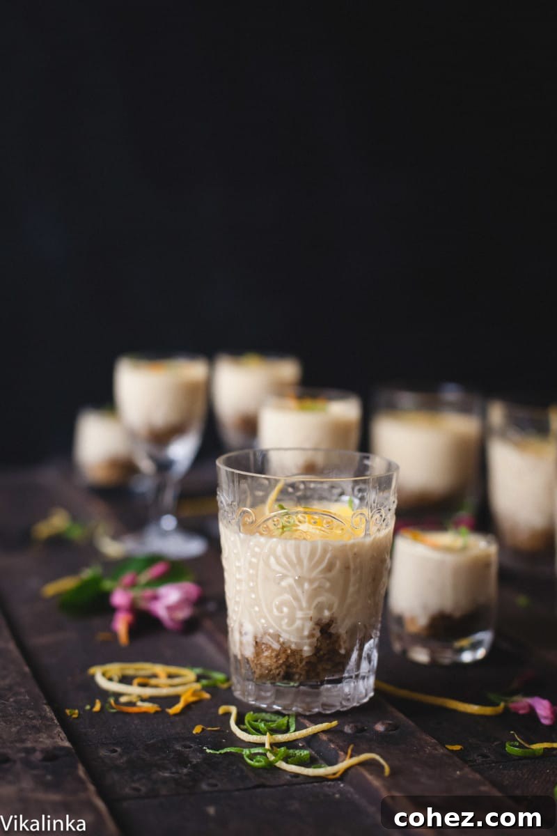 Velvety Lemon Vanilla Posset 2 Two glasses of lemon posset with a silky smooth texture, garnished with lemon zest, presented from a side view.