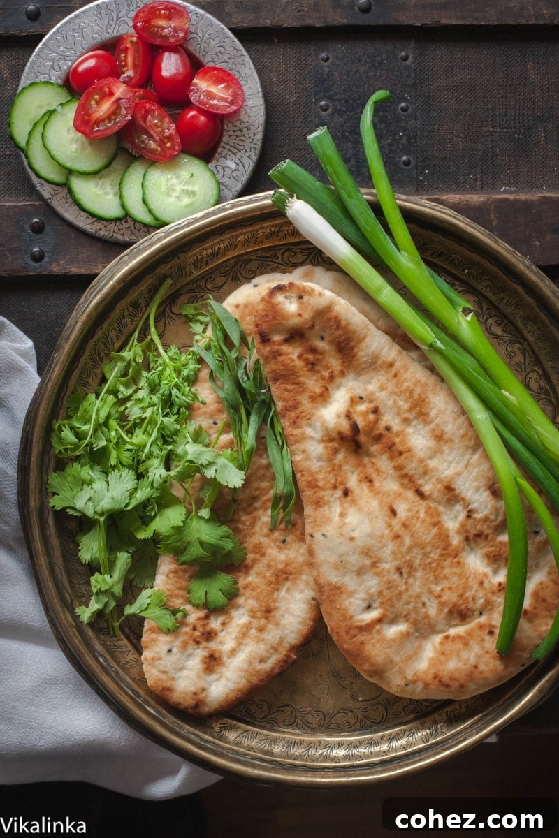 Top down shot of naan bread and fresh greens on a plate, ideal accompaniment for Satsivi