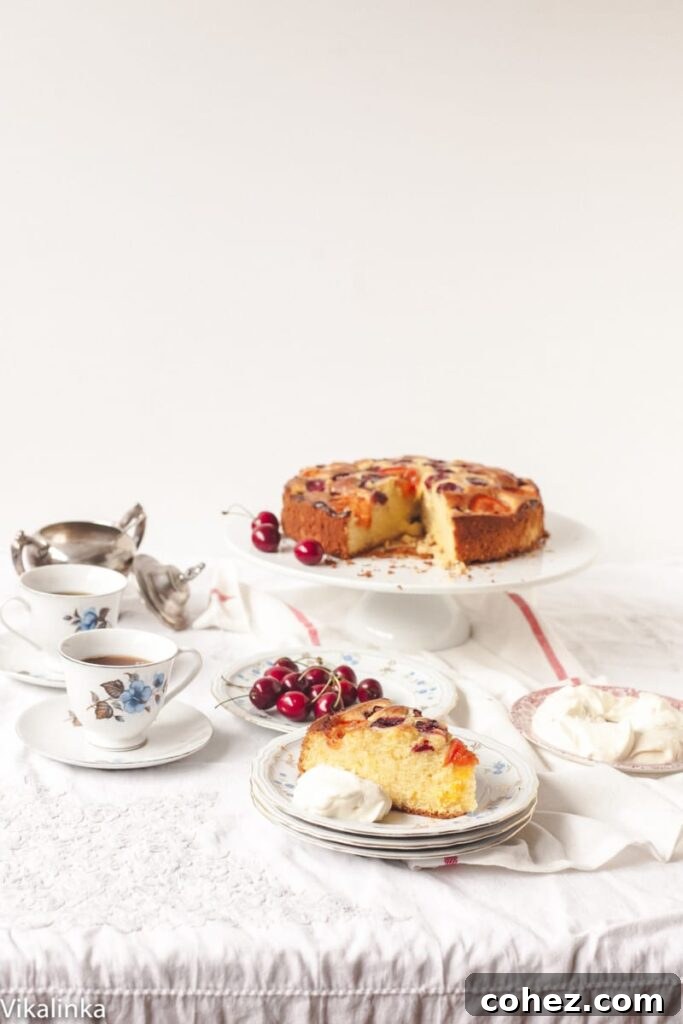 An inviting table setting featuring the cherry and apricot cake alongside a charming tea set, suggesting a perfect afternoon treat.