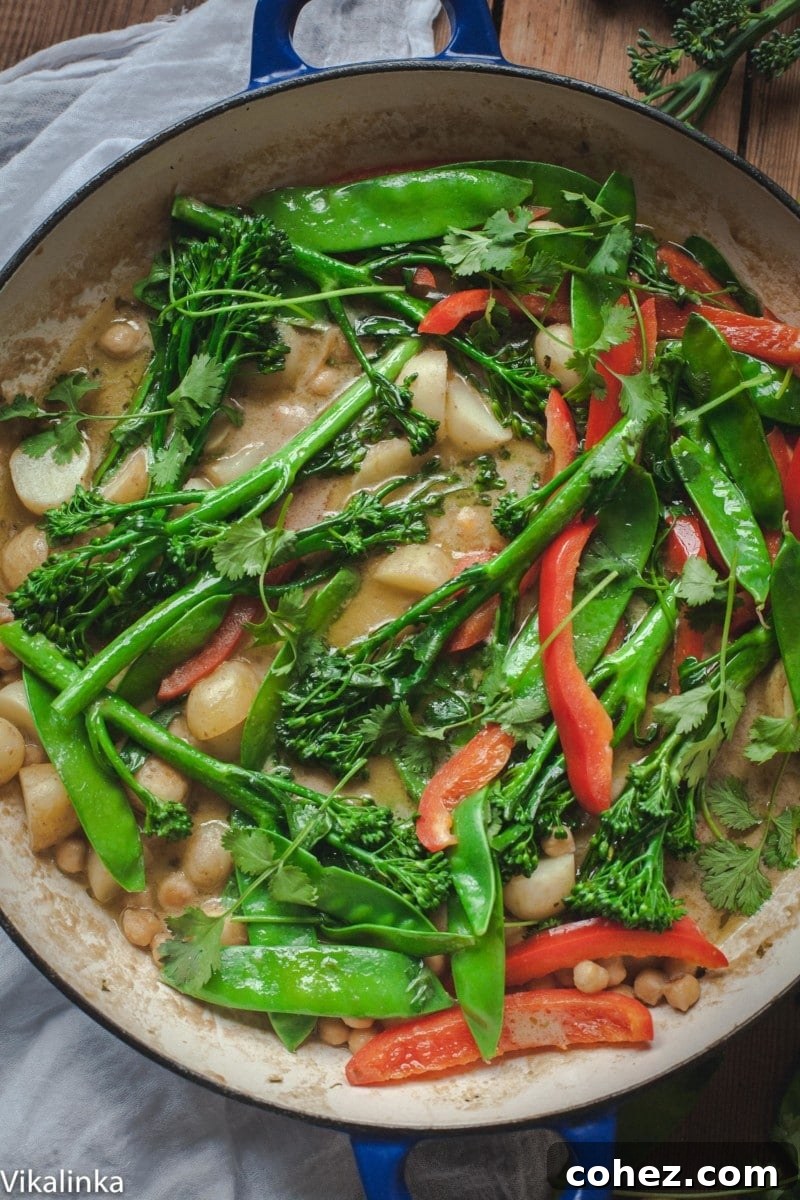 Large pot filled with Vegetarian Thai Green Curry, garnished with fresh cilantro and lime wedges.