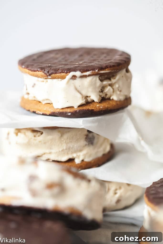 Close-up of prepared cappuccino Daim ice cream sandwiches neatly stacked with parchment paper, ready to be enjoyed.