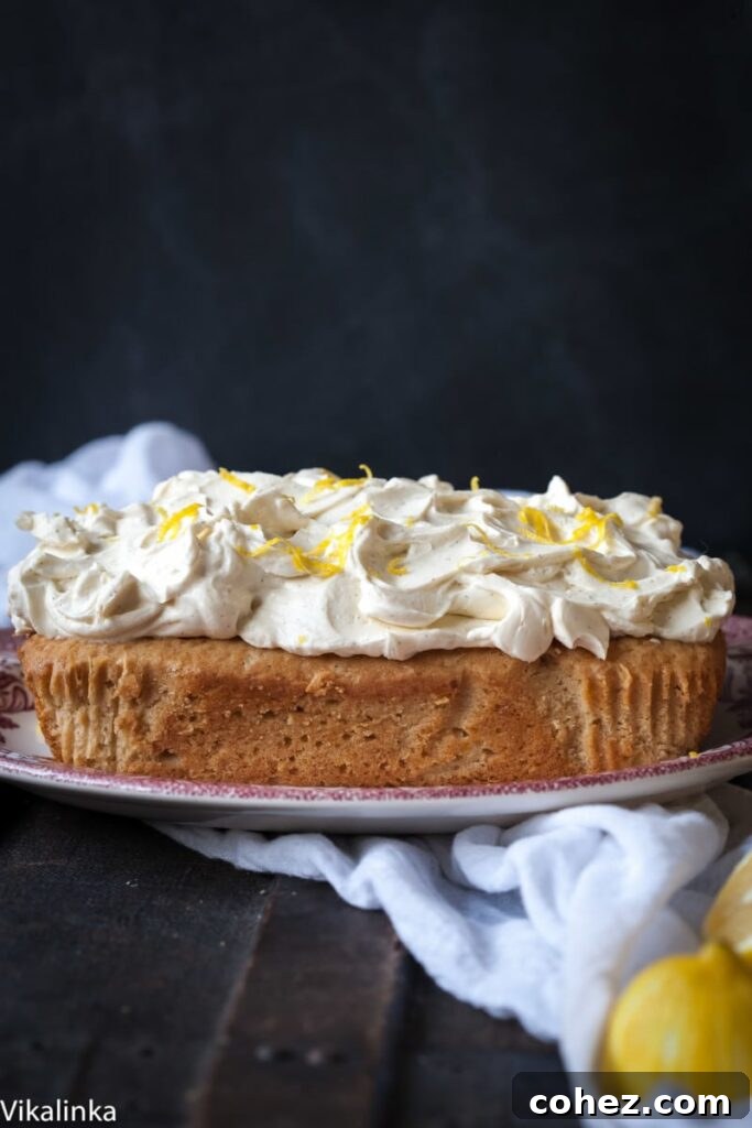 Side view of lemon ricotta cake on a plate with lemons