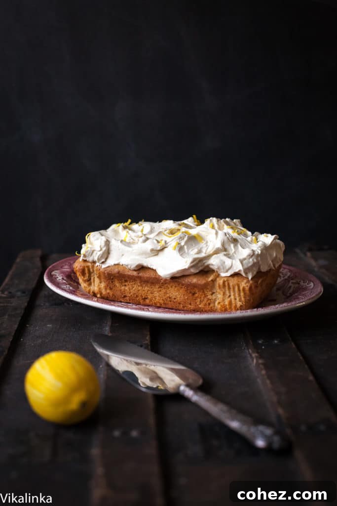 Cake on a platter beside cake slicer and lemon