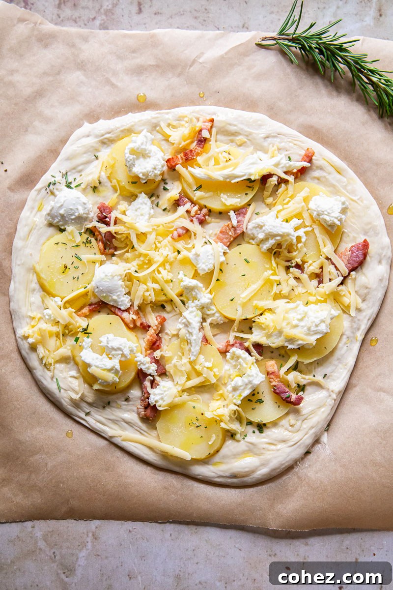 pizza dough topped with potatoes, pancetta and cheese, unbaked and ready for the oven