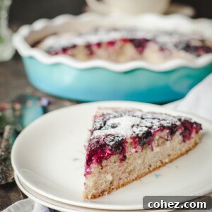 A beautifully presented slice of Wild Blackberry Tea Cake on a small white plate.