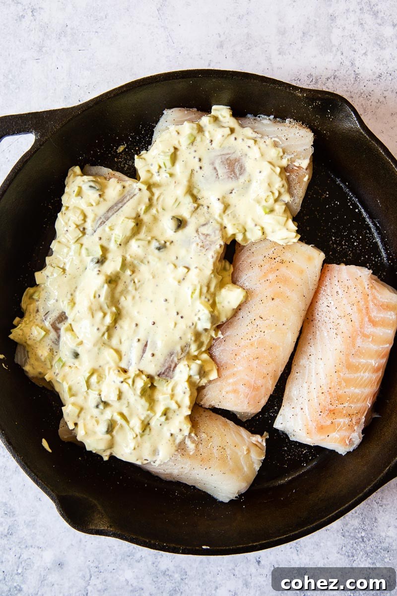 Golden Baked Cod with Zesty Mustard Sauce 5 A pristine raw cod fillet, artfully covered with a rich, creamy, and textured mustard sauce, poised for baking to golden perfection