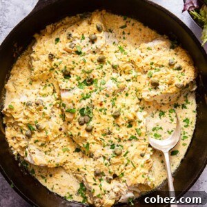 Baked fish in a rich cream sauce in a black skillet, ready to be served