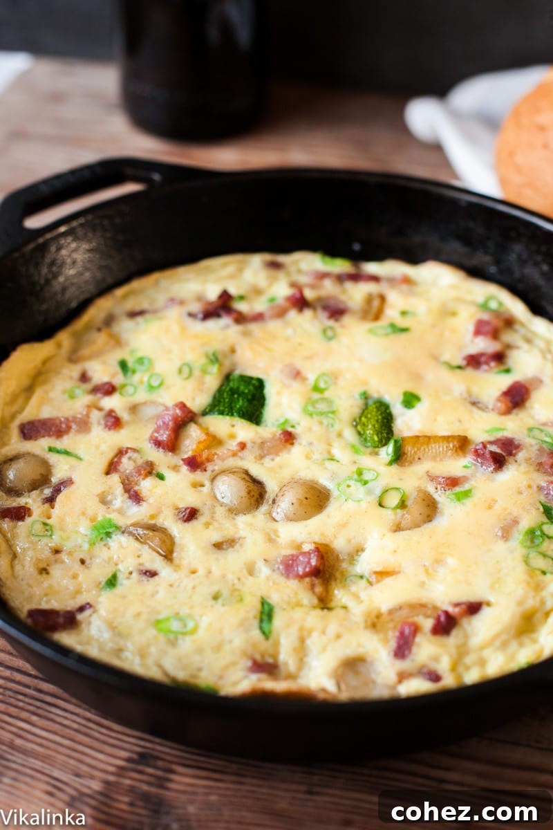 Loaded French Omelette with Bacon, Potatoes and Zucchini 6 A delicious omelette with bacon and potatoes cooking in a cast iron pan, ready to be served