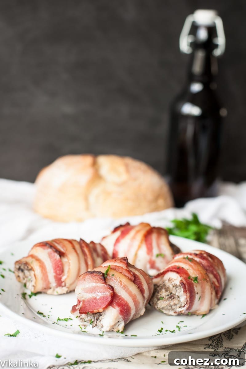 Side view of perfectly cooked bacon wrapped chicken thighs on a serving dish, showcasing the crispy bacon and golden-brown skin