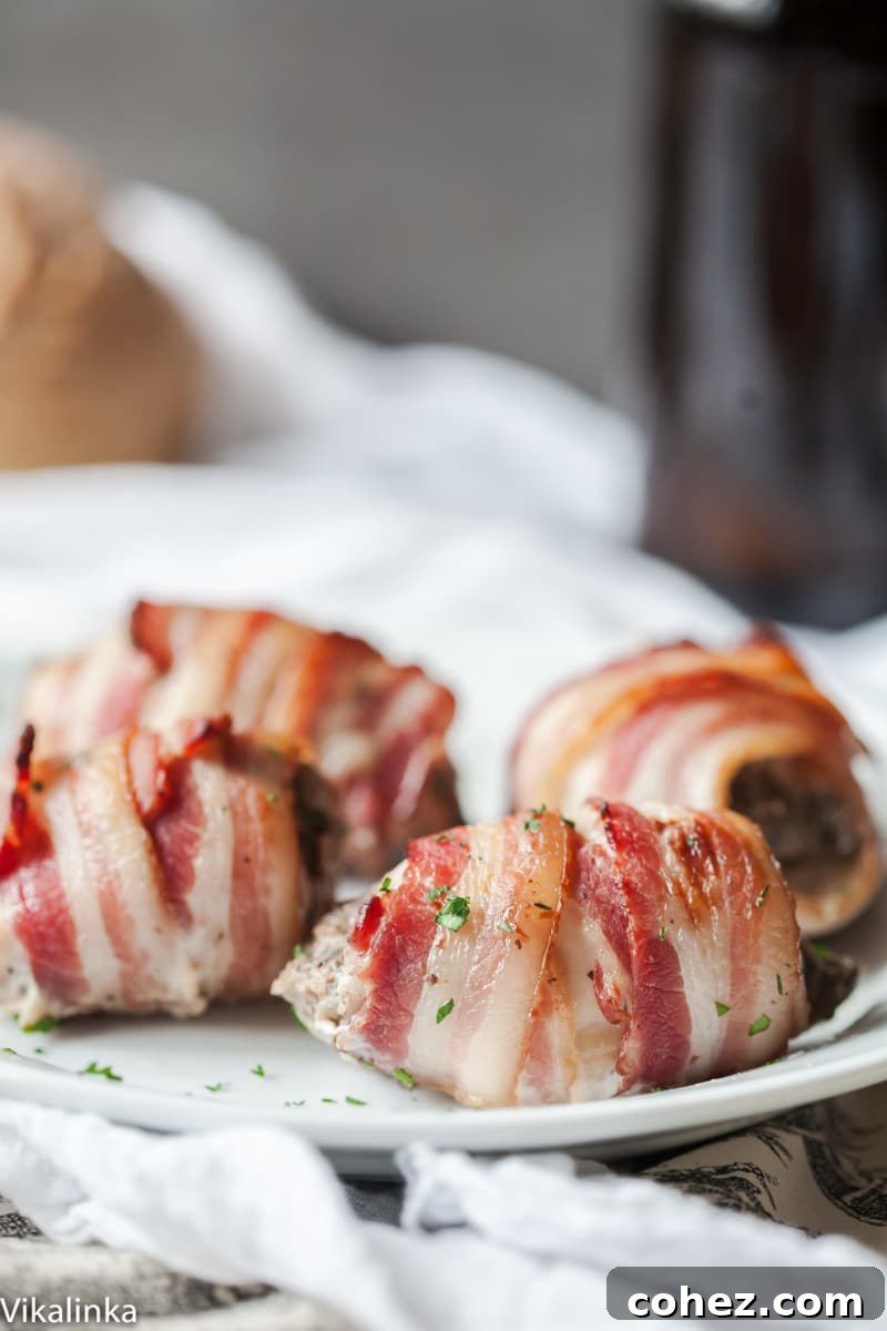Close-up of a single bacon wrapped chicken thigh, showing the crispy exterior and golden-brown color, hinting at the savory filling within