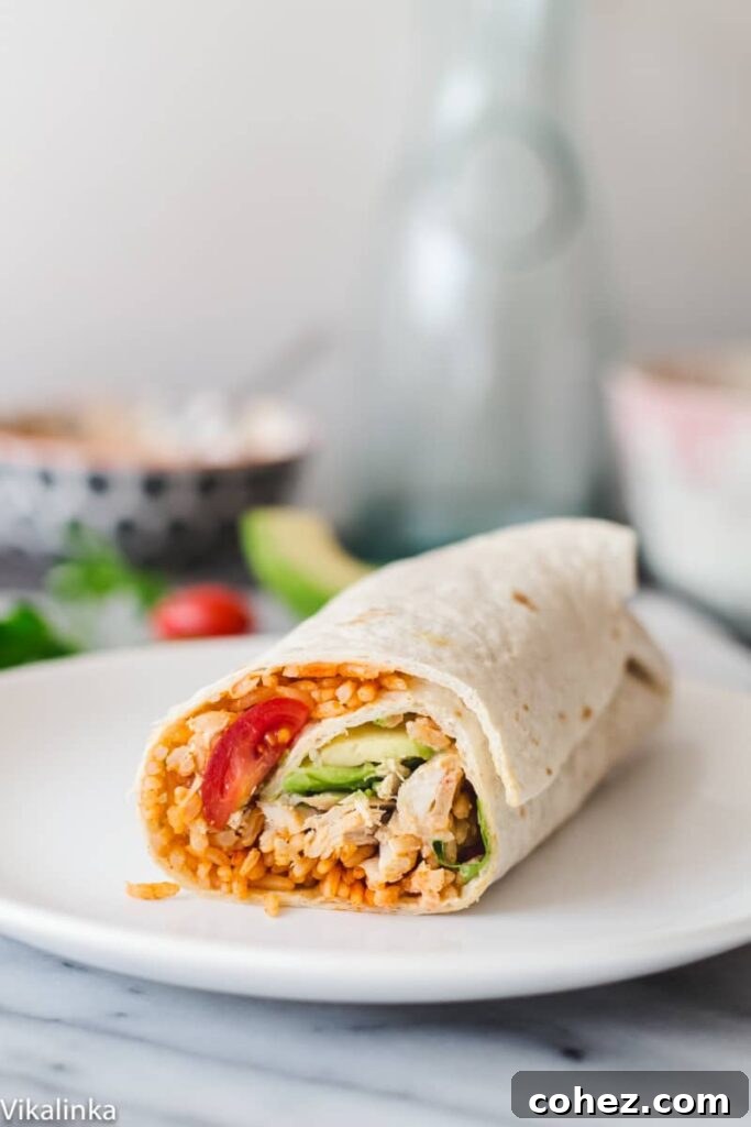 A perfectly rolled Peri Peri Rice and Chicken Wrap presented elegantly on a white plate, ready to be enjoyed.