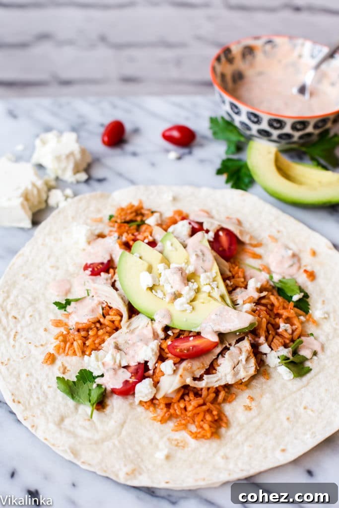 A vibrant and delicious Peri Peri Rice and Chicken Wrap, garnished with fresh avocado and spicy yogurt sauce, promising an exciting lunch