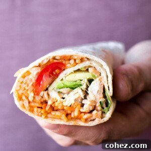 Hand holding peri peri rice and chicken wrap showing cross-section
