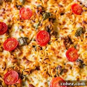 sausage pasta baked with cherry tomatoes on top in round pan
