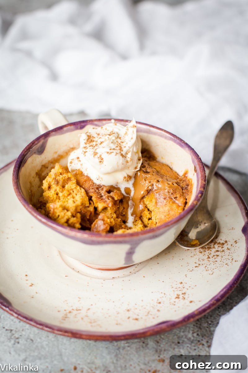 Side shot of Spiced pumpkin cake in a mug with cream on top