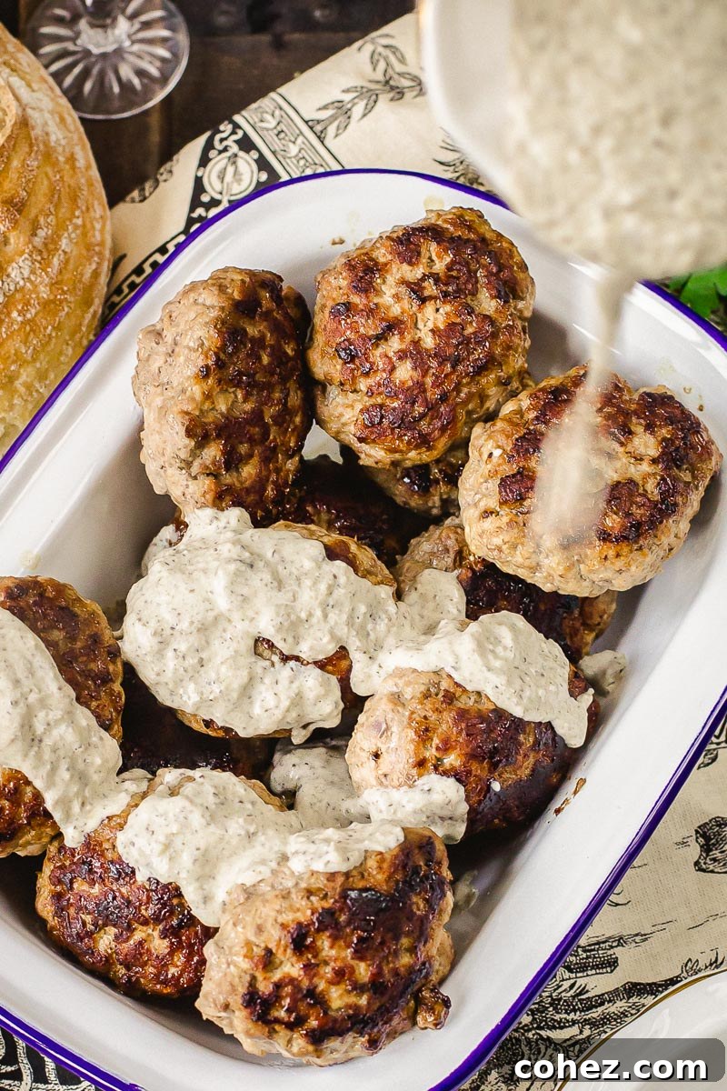 Perfectly seared beef cutlets being generously drizzled with a rich, creamy sauce, showcasing their irresistible appeal.