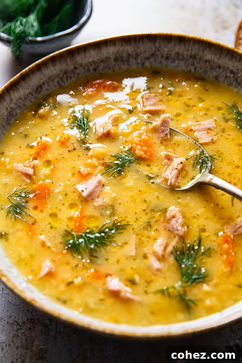 Close-up view of Yellow Split Pea and Ham Soup, generously sprinkled with fresh dill, highlighting its rich texture and vibrant garnish.